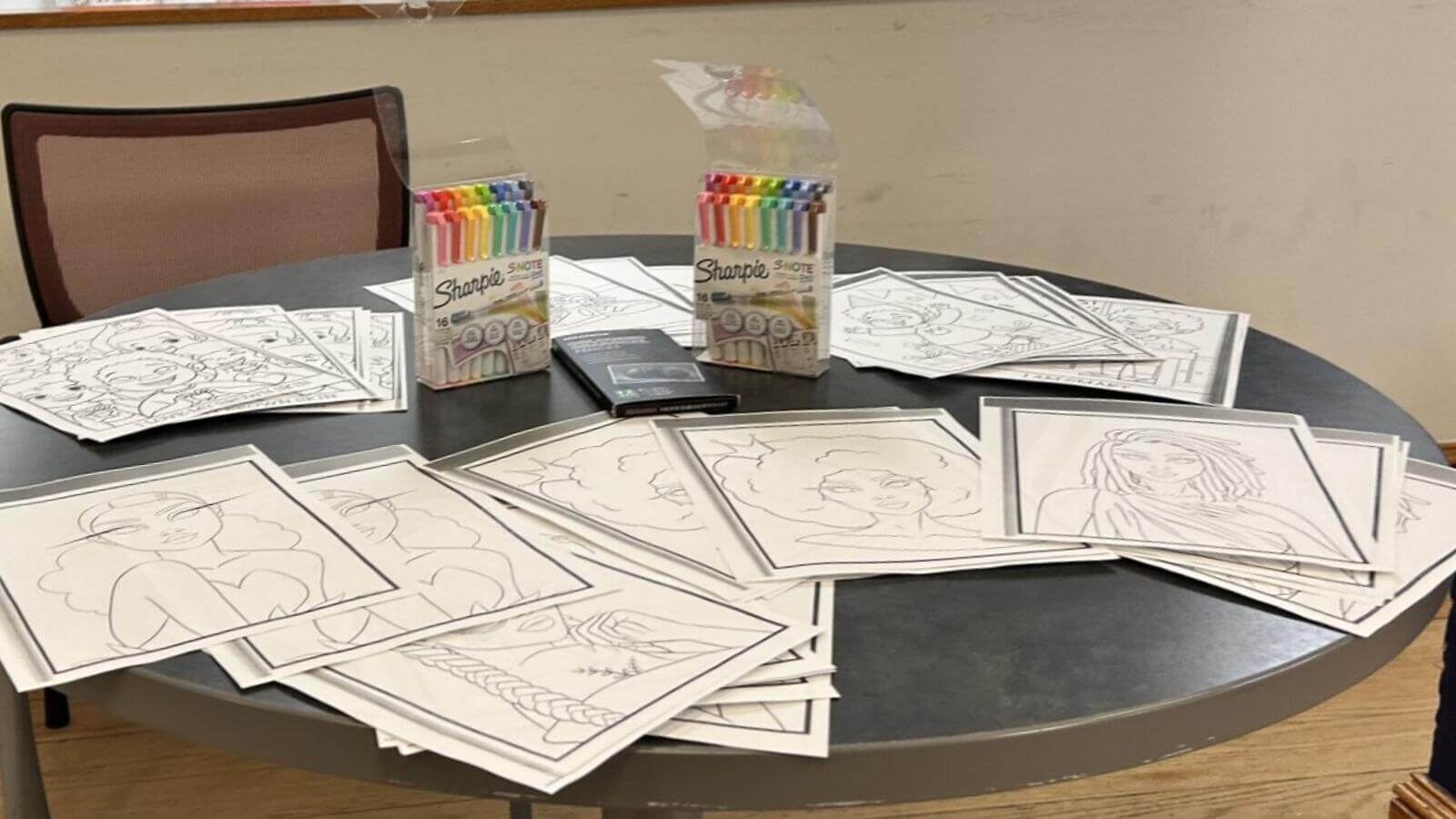 Photo of coloring pages and markers on a table