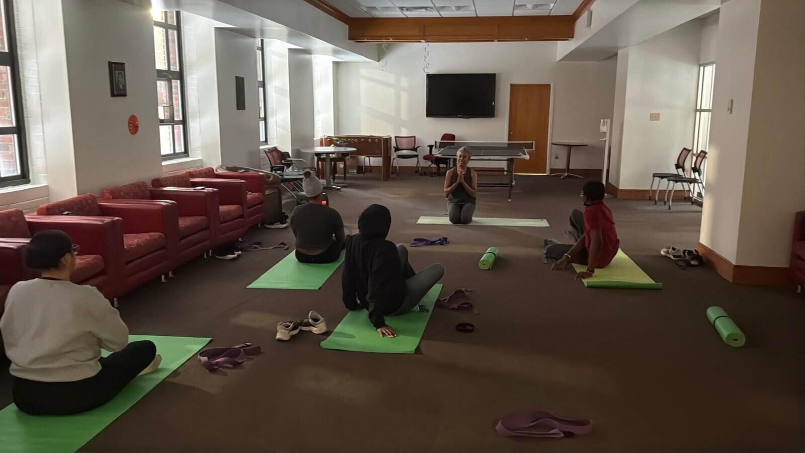 Yoga class with students and instructor sitting on yoga mats